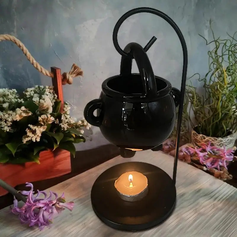 Hanging ceramic cauldron wax burner suspended from a black metal stand — view 1 of 5