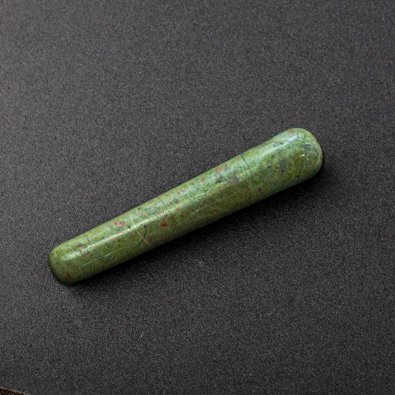 Smooth polished crystal massage wand in assorted gemstones on a dark surface — view 10 of 12