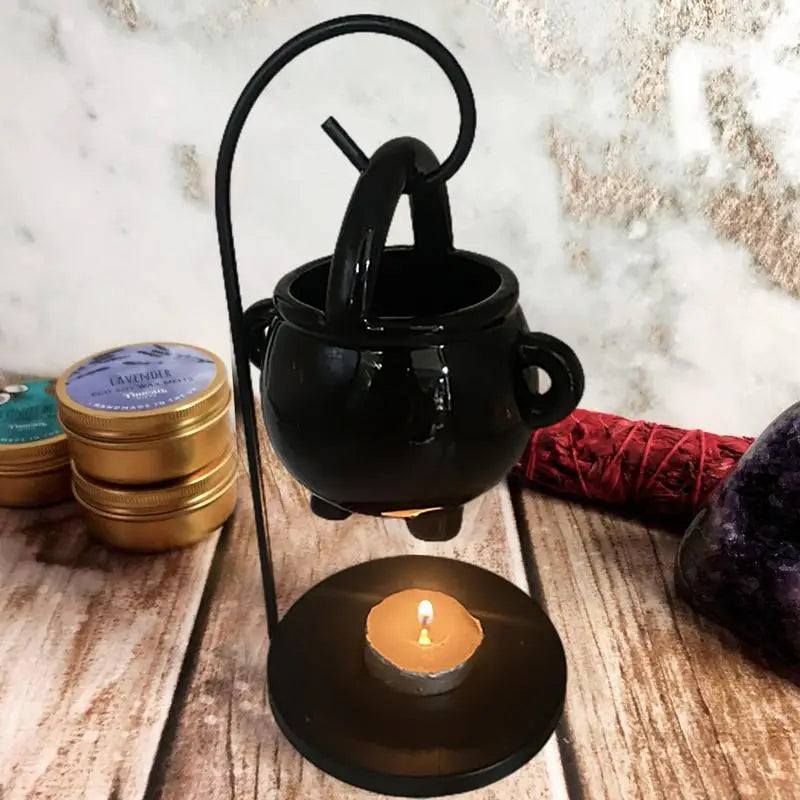 Hanging ceramic cauldron wax burner suspended from a black metal stand — view 4 of 5