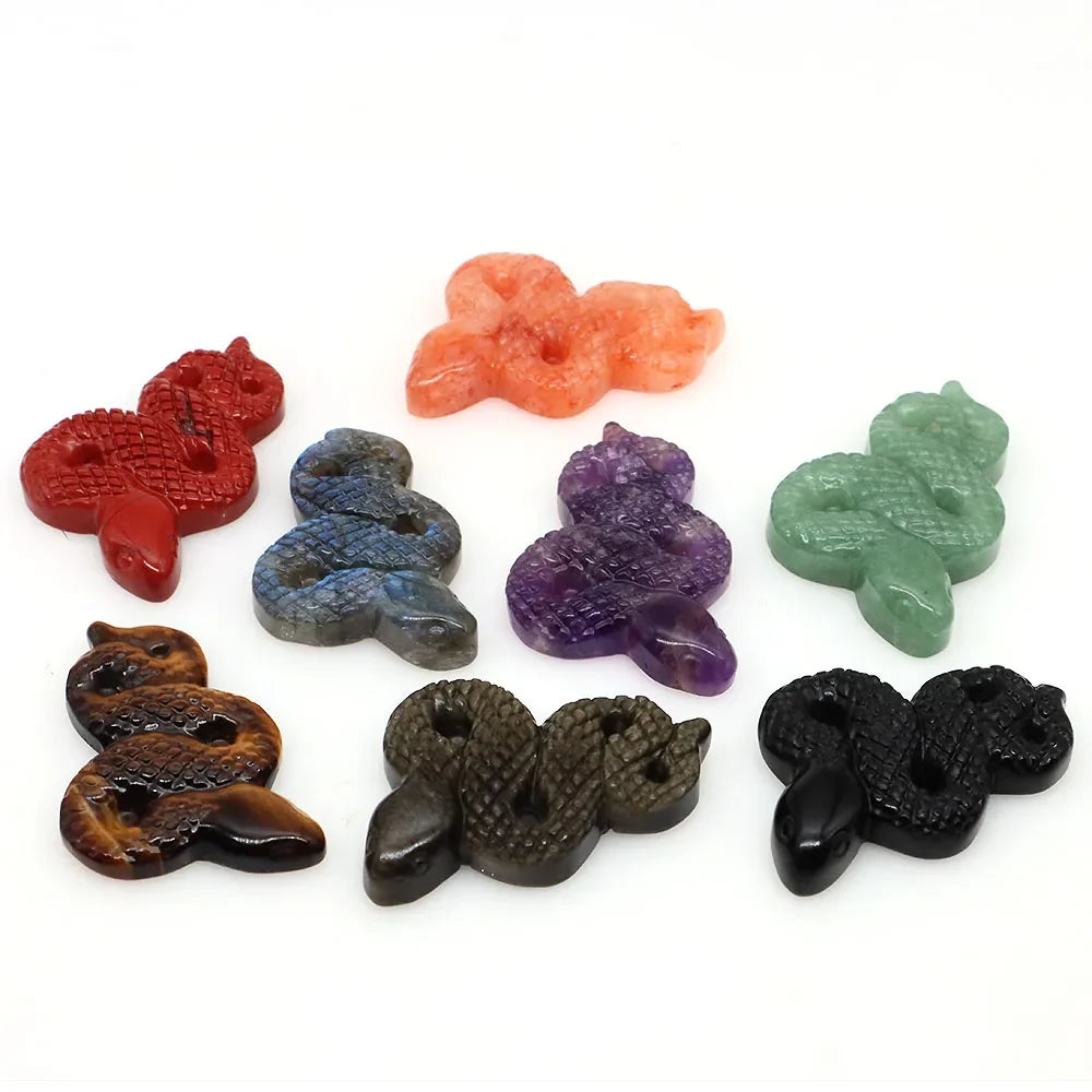 Carved gemstone snake figurine coiled on a dark surface — view 5 of 12