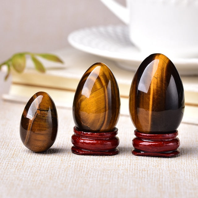 Polished carved crystal egg in assorted gemstones on a dark surface — view 9 of 10