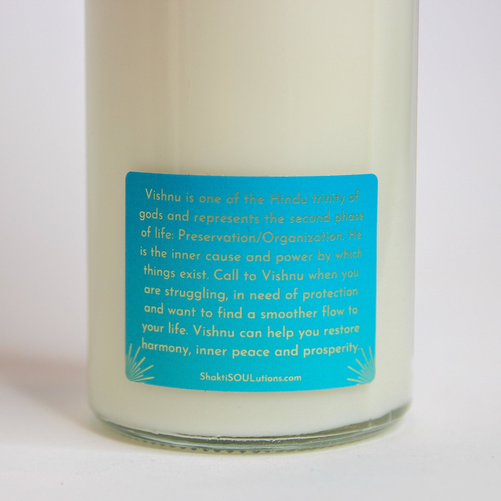 The Vishnu altar candle styled on a dark altar surface