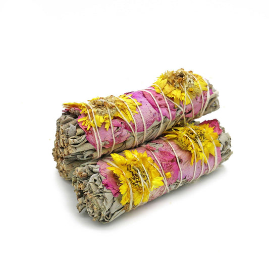 Bundle of organic white sage wrapped with pink rose petals and yellow sunflowers, tied with cotton string