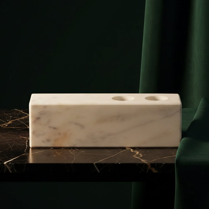 White marble candle holder block with two taper holes on dark marble
