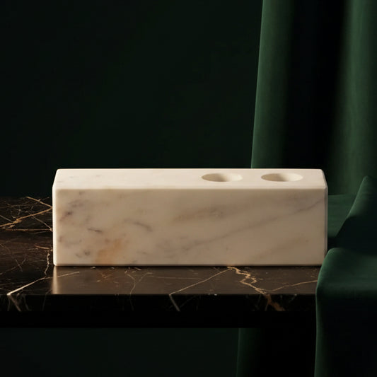 White marble candle holder block with two taper holes on dark marble