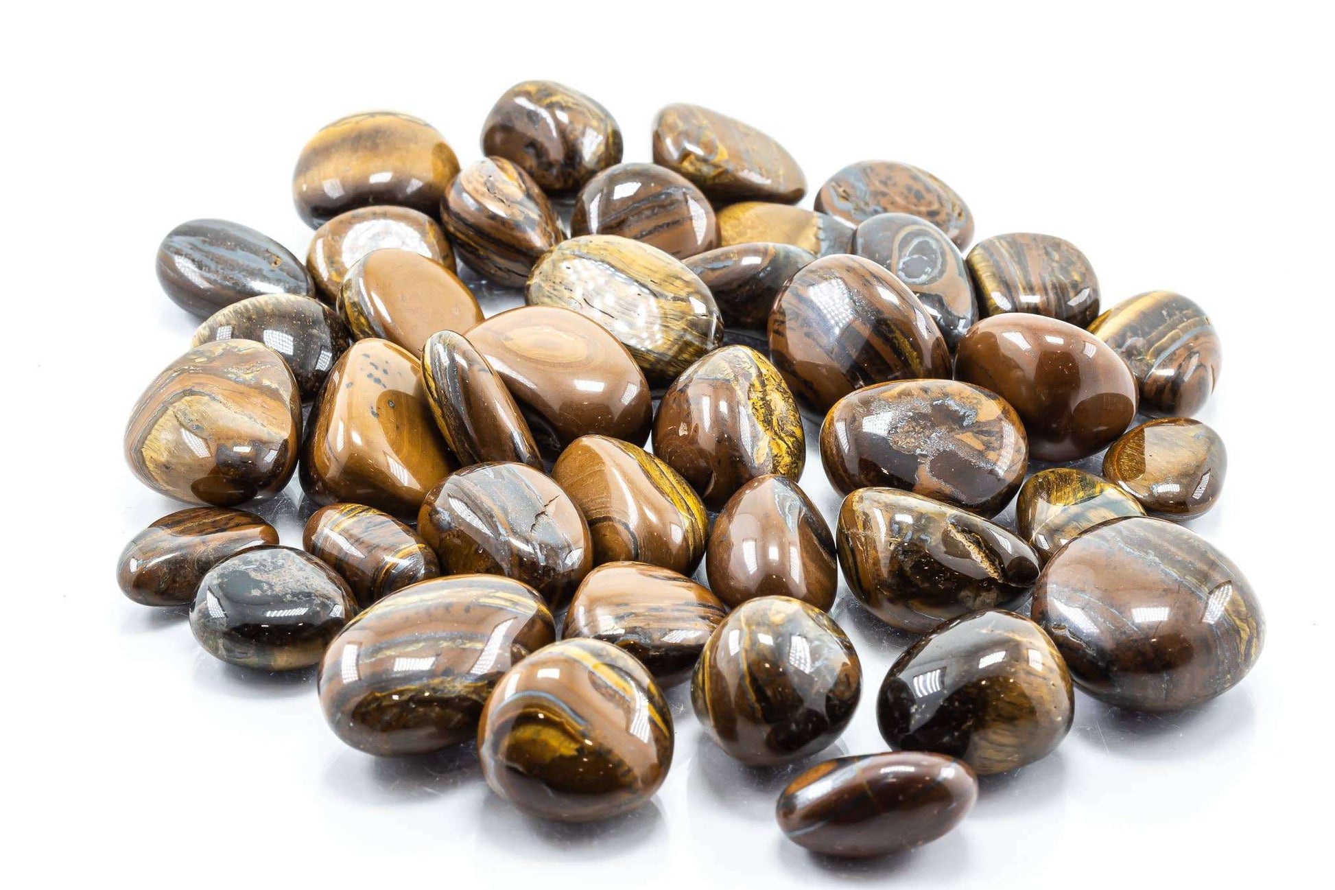 A pile of polished tiger iron tumbled stones showing banded gold, brown and dark grey layers