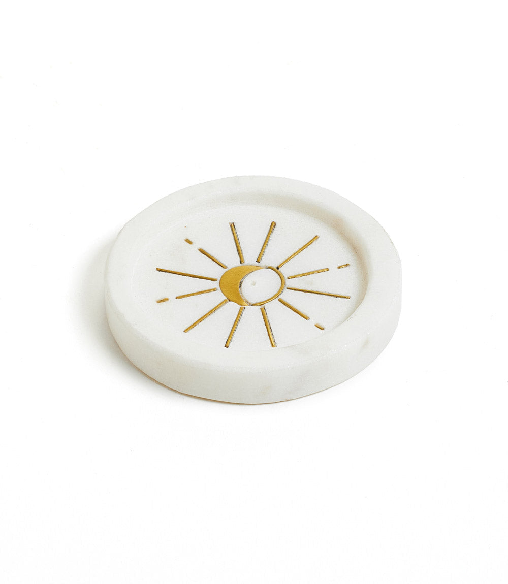 White marble incense dish with a brass crescent moon and radiating rays inlaid in the center