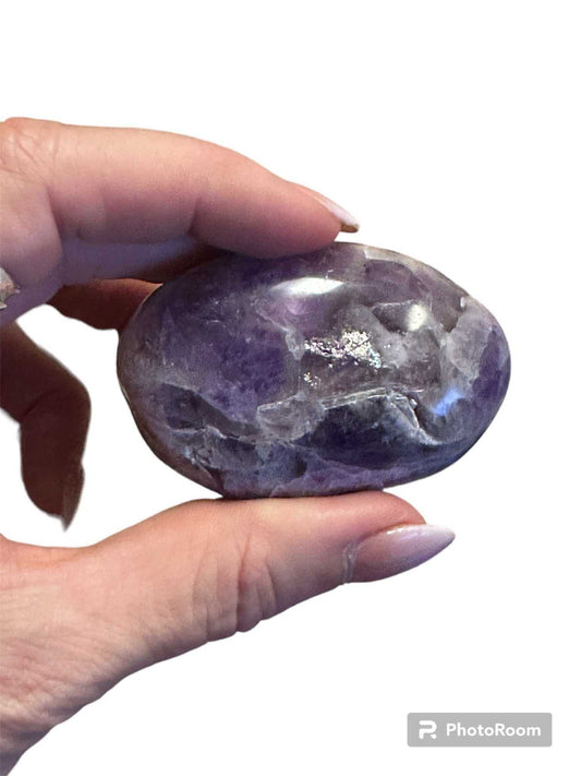A smooth, polished amethyst palm stone in a deep violet-purple tone.