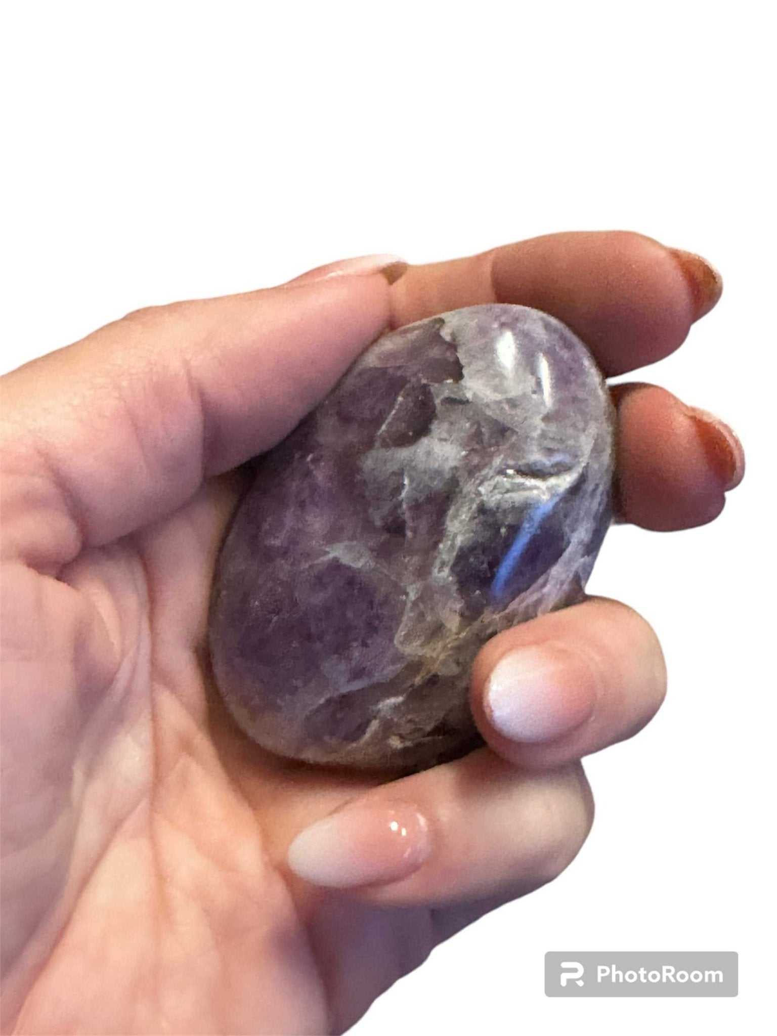 An amethyst palm stone shown from a second angle, its surface polished smooth.