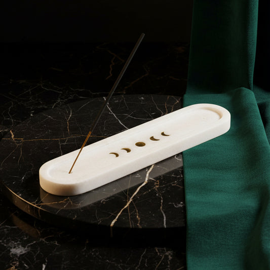 Long white marble incense tray with brass moon phase inlay on black marble, stick burning