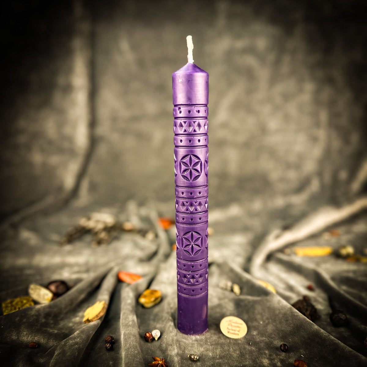 Rozetka rosette beeswax pillar candle in purple on draped fabric
