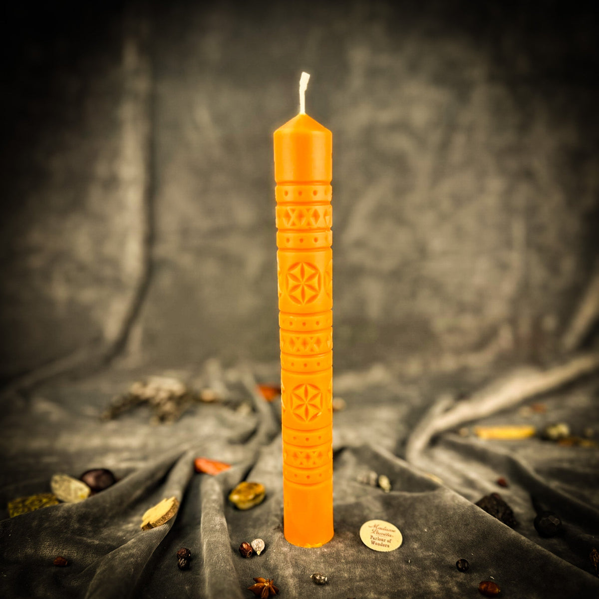 Rozetka rosette beeswax pillar candle in orange on draped fabric