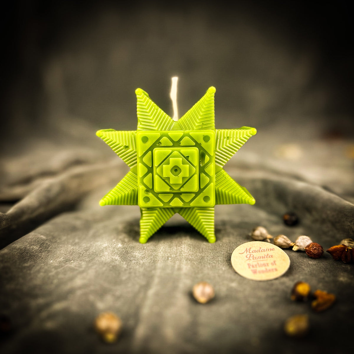 Chartreuse Ruzha star candle standing on gray velvet