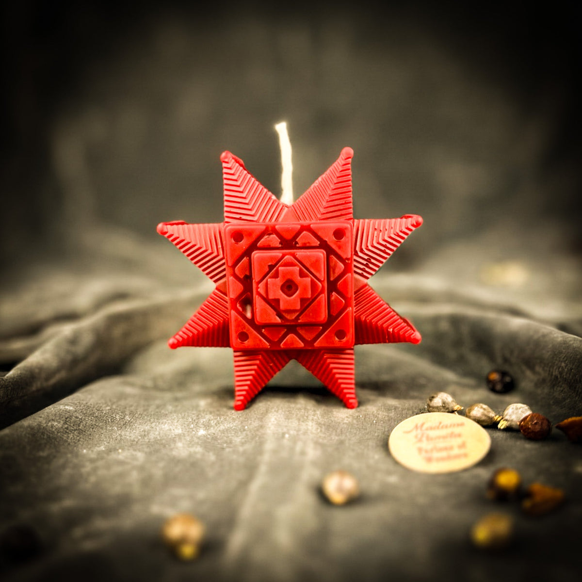 Red Ruzha star candle standing on gray velvet