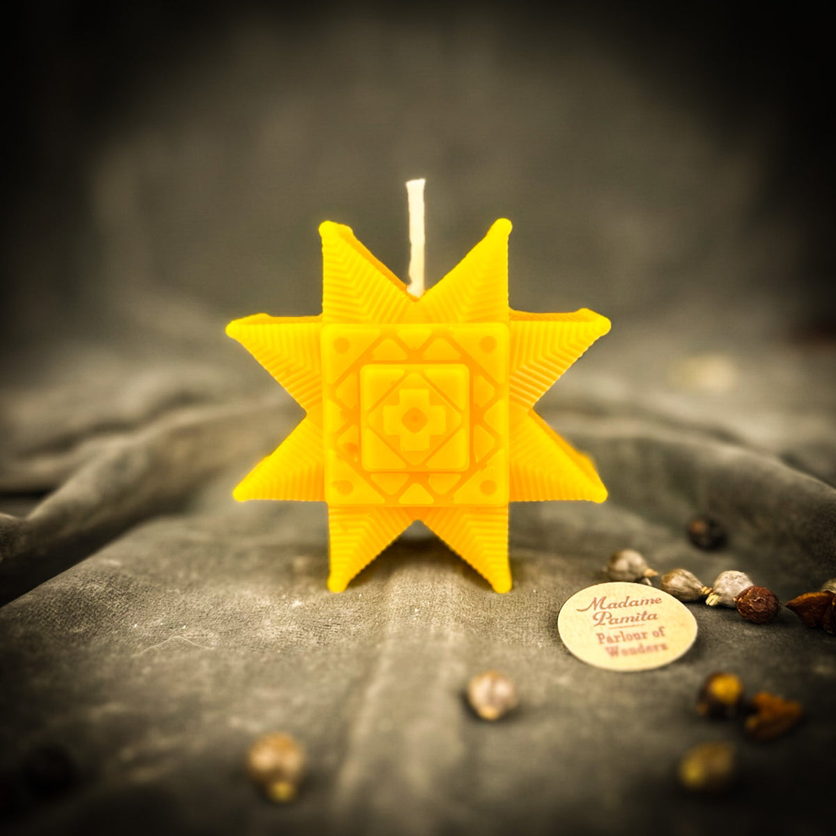 Yellow Ruzha star candle standing on gray velvet