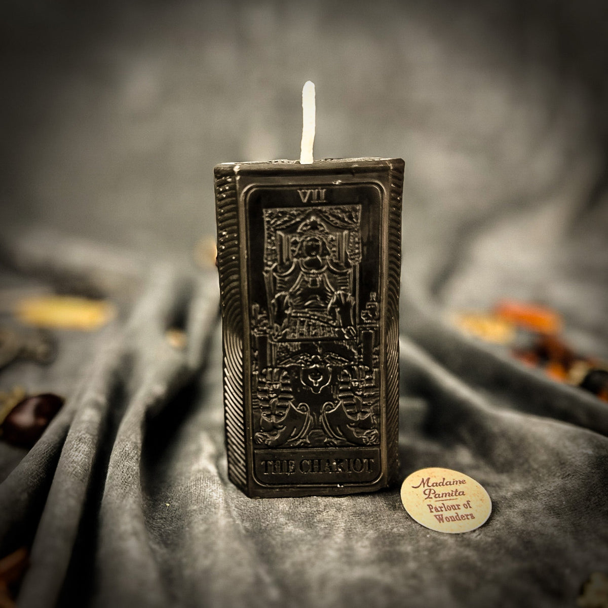 Black beeswax candle molded as The Chariot tarot card, the charioteer design raised in relief