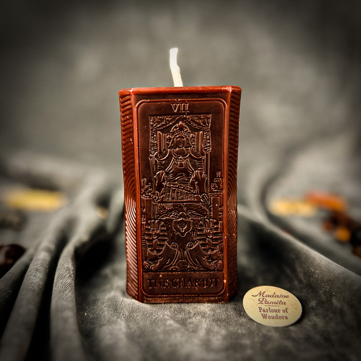 Reddish brown beeswax The Chariot tarot card candle, the numeral VII visible at the top