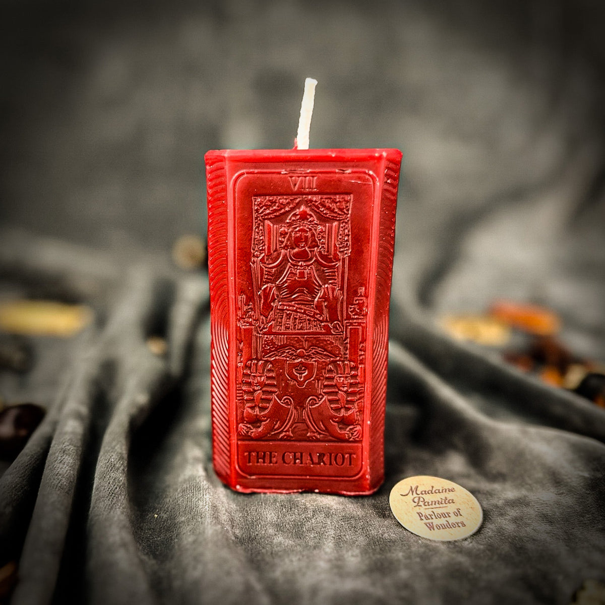 Red beeswax The Chariot tarot card candle with the relief design catching the light