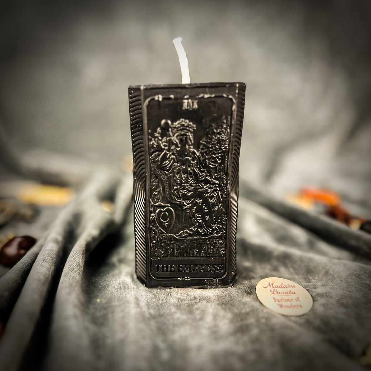Black beeswax The Empress tarot card candle, the relief catching the light