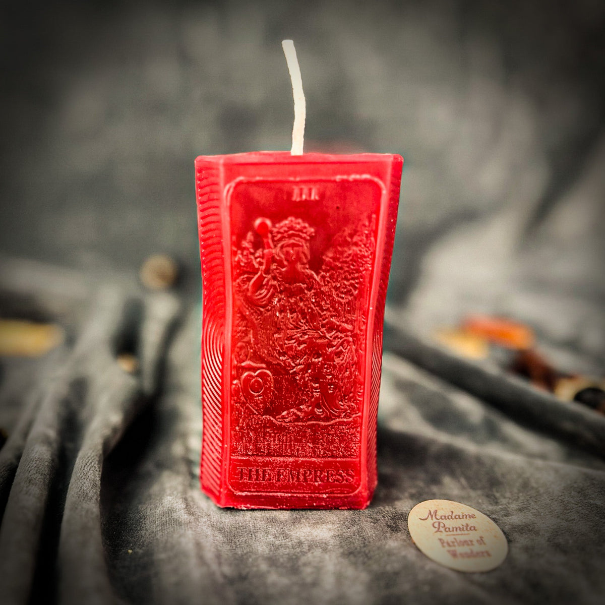 Red beeswax The Empress tarot card candle with THE EMPRESS lettered along the base