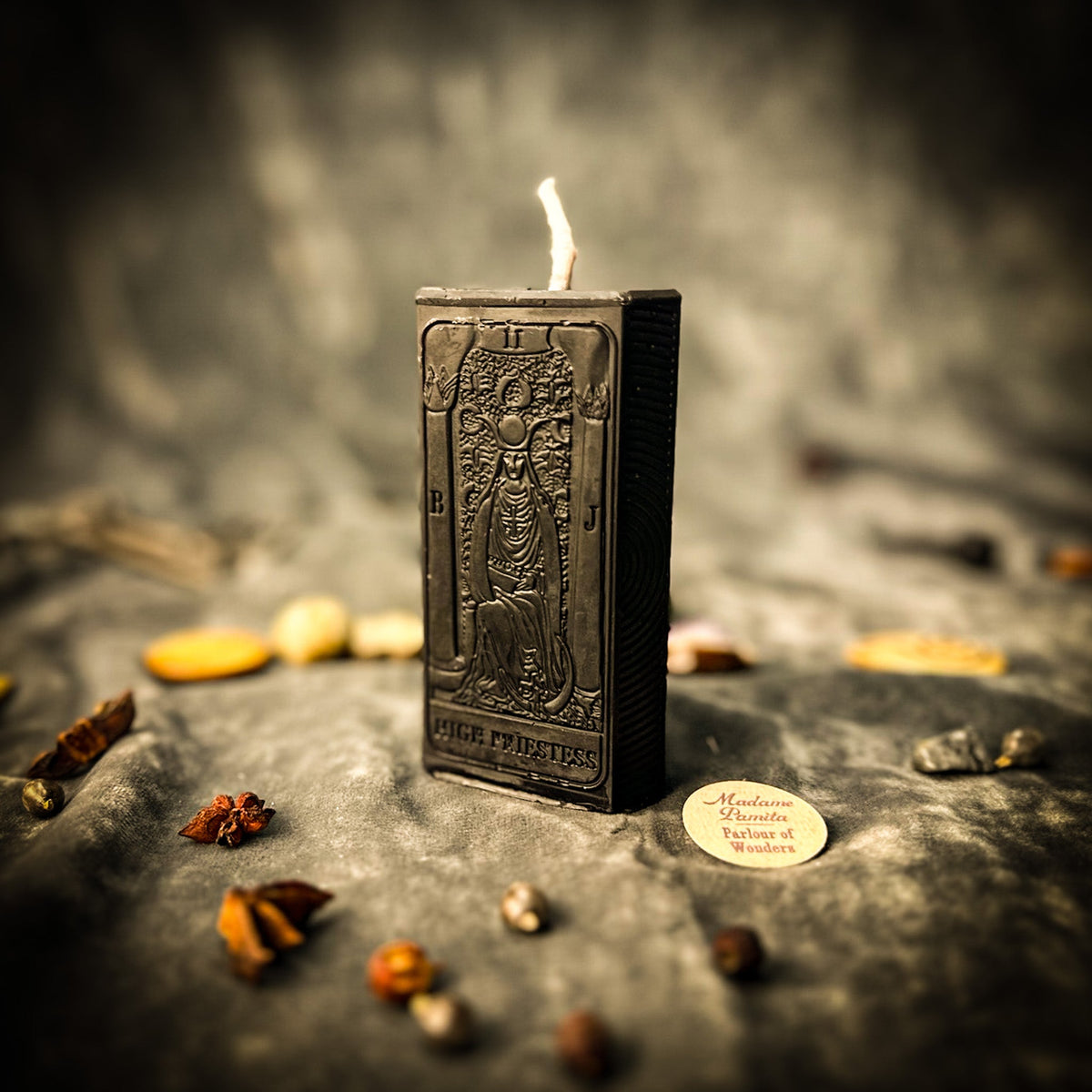 The High Priestess beeswax tarot candle in black on draped gray fabric