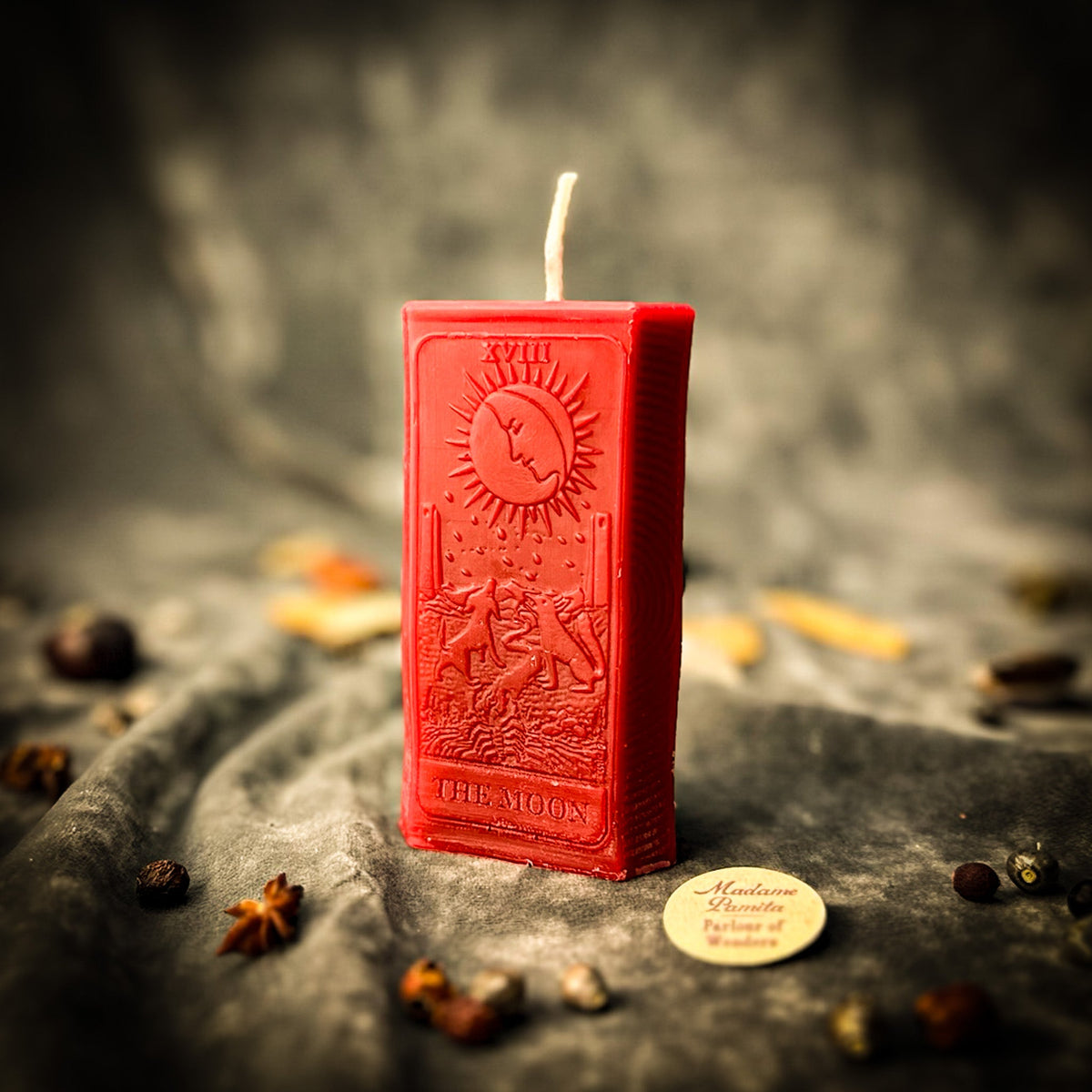 Red beeswax The Moon tarot card candle with THE MOON lettered along its base