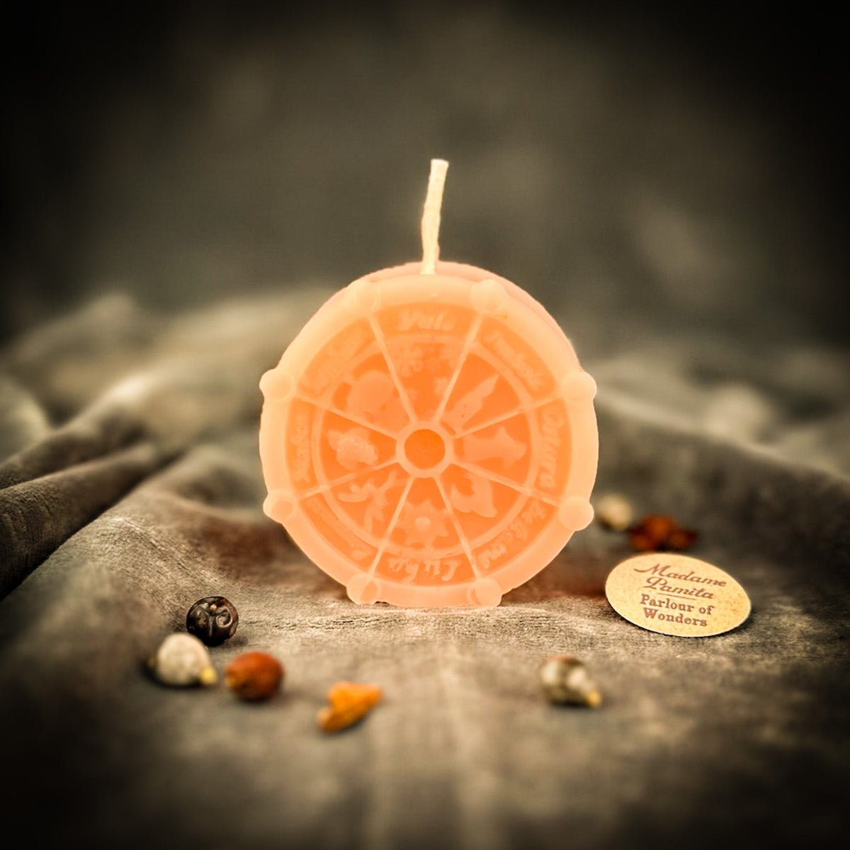 Peach Wheel of the Year candle, the eight segments and their symbols evenly spaced.
