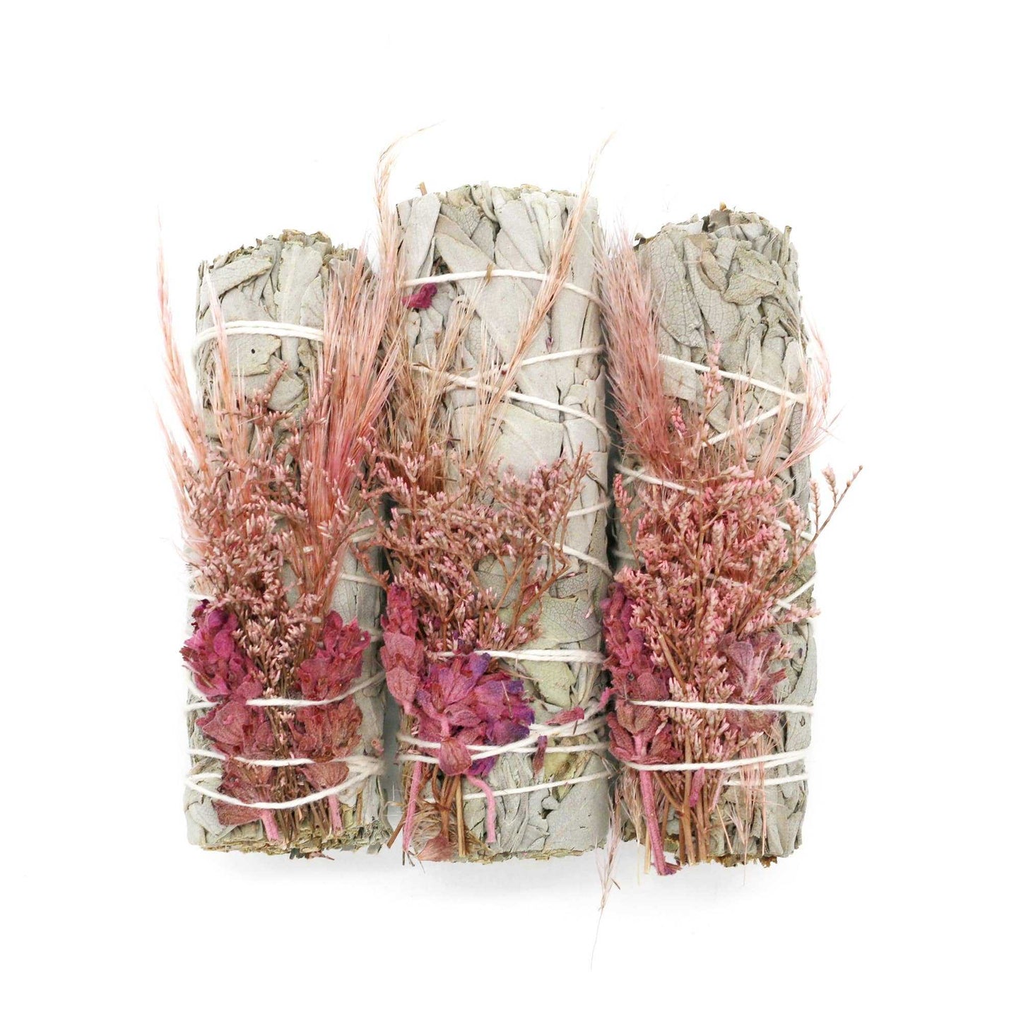 White sage smudge stick wrapped with a bouquet of pink dried flowers, close-up detail