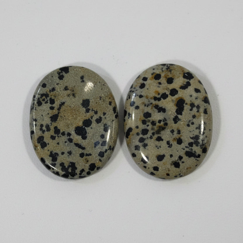Two dalmatian jasper comfort stones side by side, showing different spot patterns