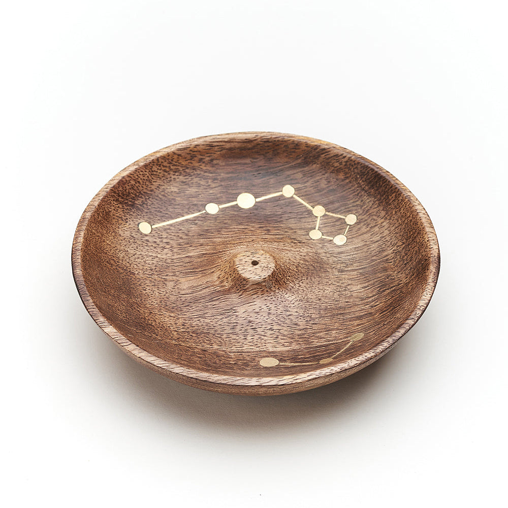 Round mango wood incense holder with a brass star constellation inlaid across the bowl