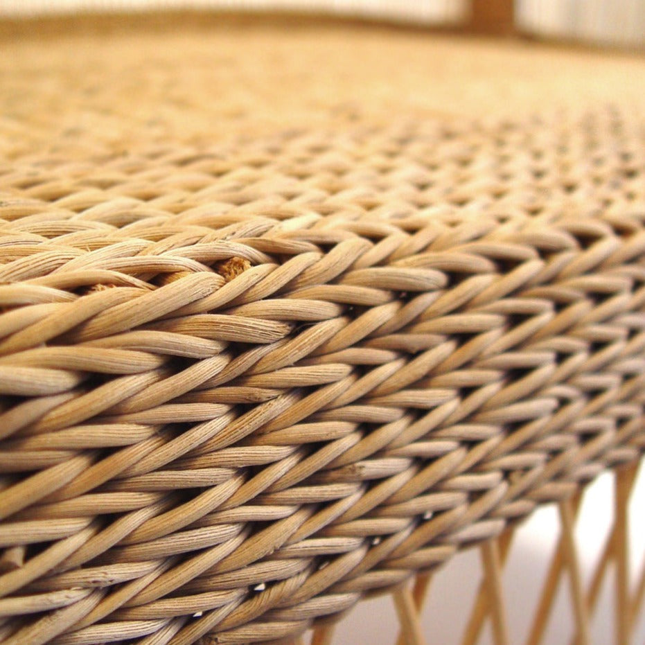 Close detail of the handwoven cane across the chair back