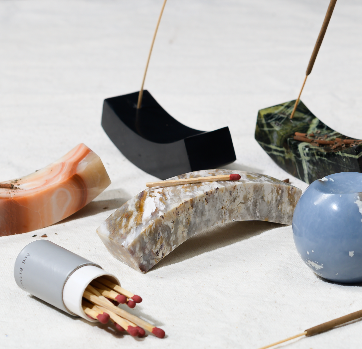 Black onyx Curve holder styled with other Andean stone pieces, matches and a pale blue sphere