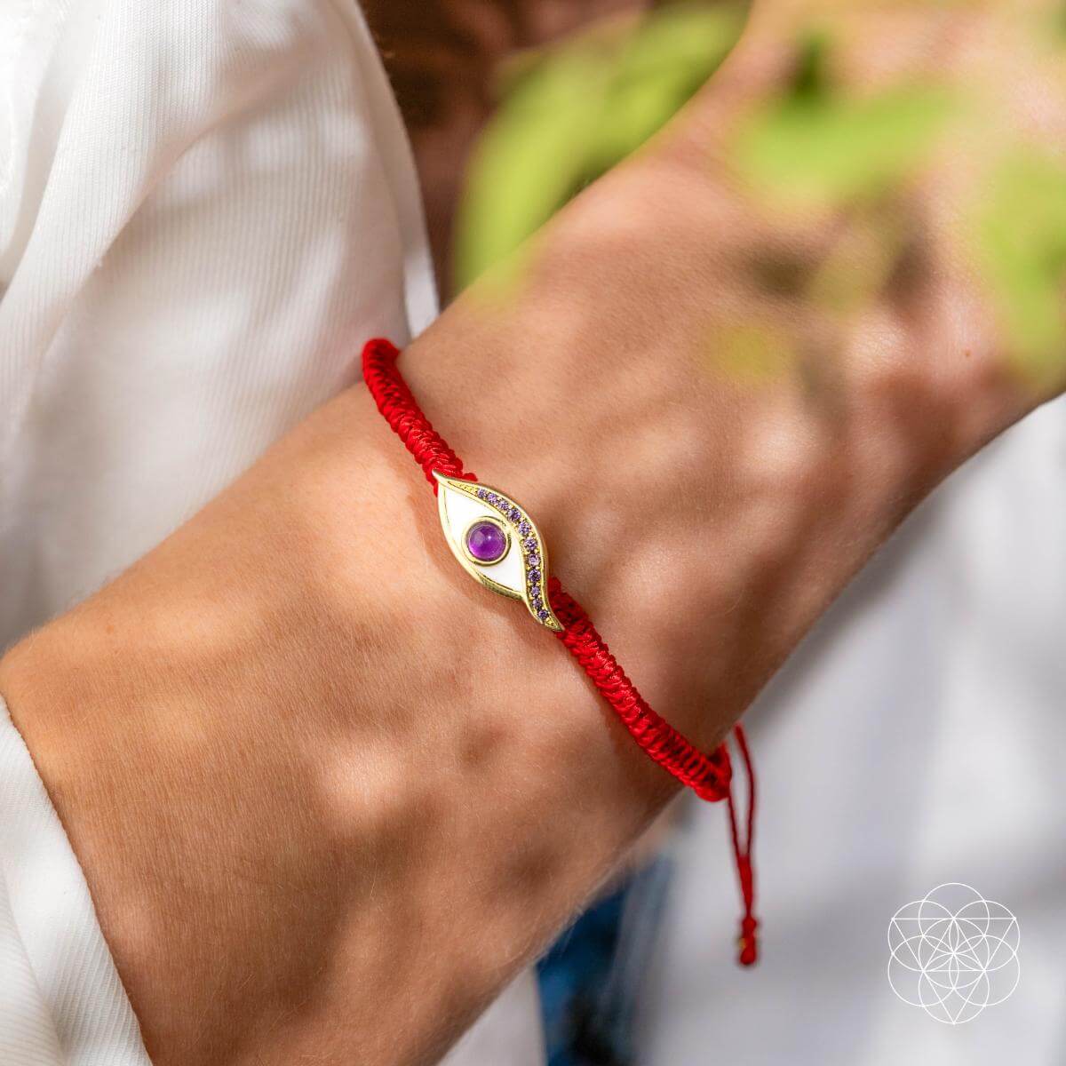 Four-strand red string bracelet with a 14K gold-plated evil eye charm set with a purple amethyst iris — detail view 2