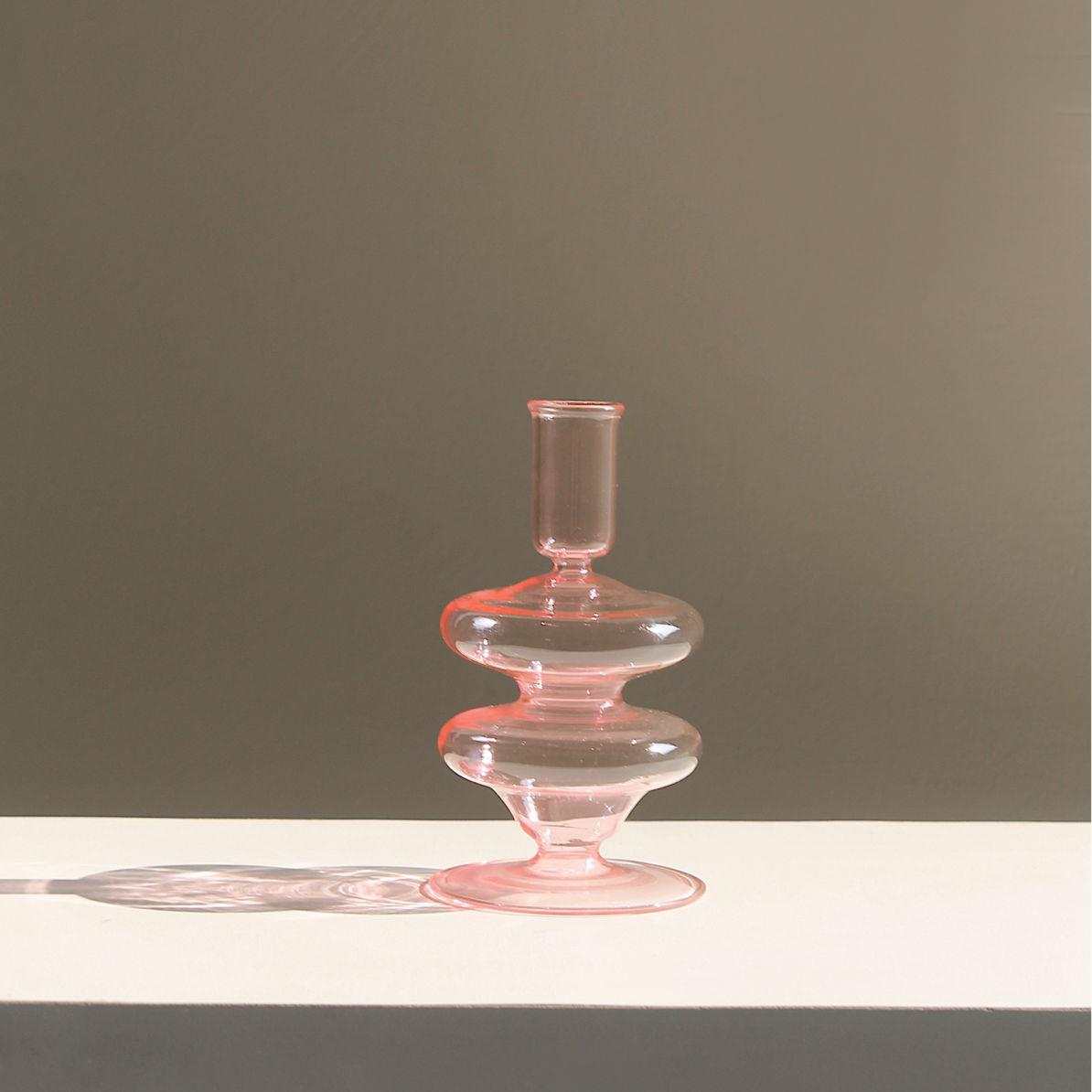 Pink Siri glass candle holder with its double disc stem in daylight