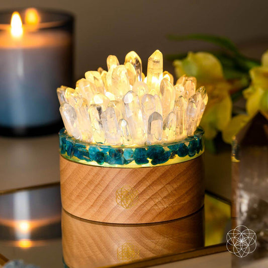 Blue Apatite and Clear Quartz crystal lamp glowing on a wooden base