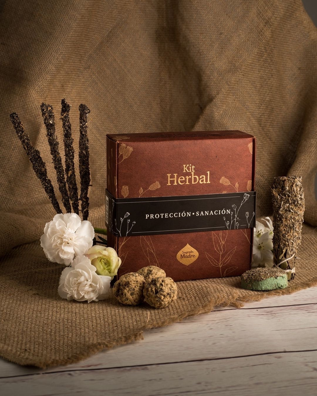 Open Sage Herbal box with incense sticks, smudge bombs and a smudge stick arranged around it
