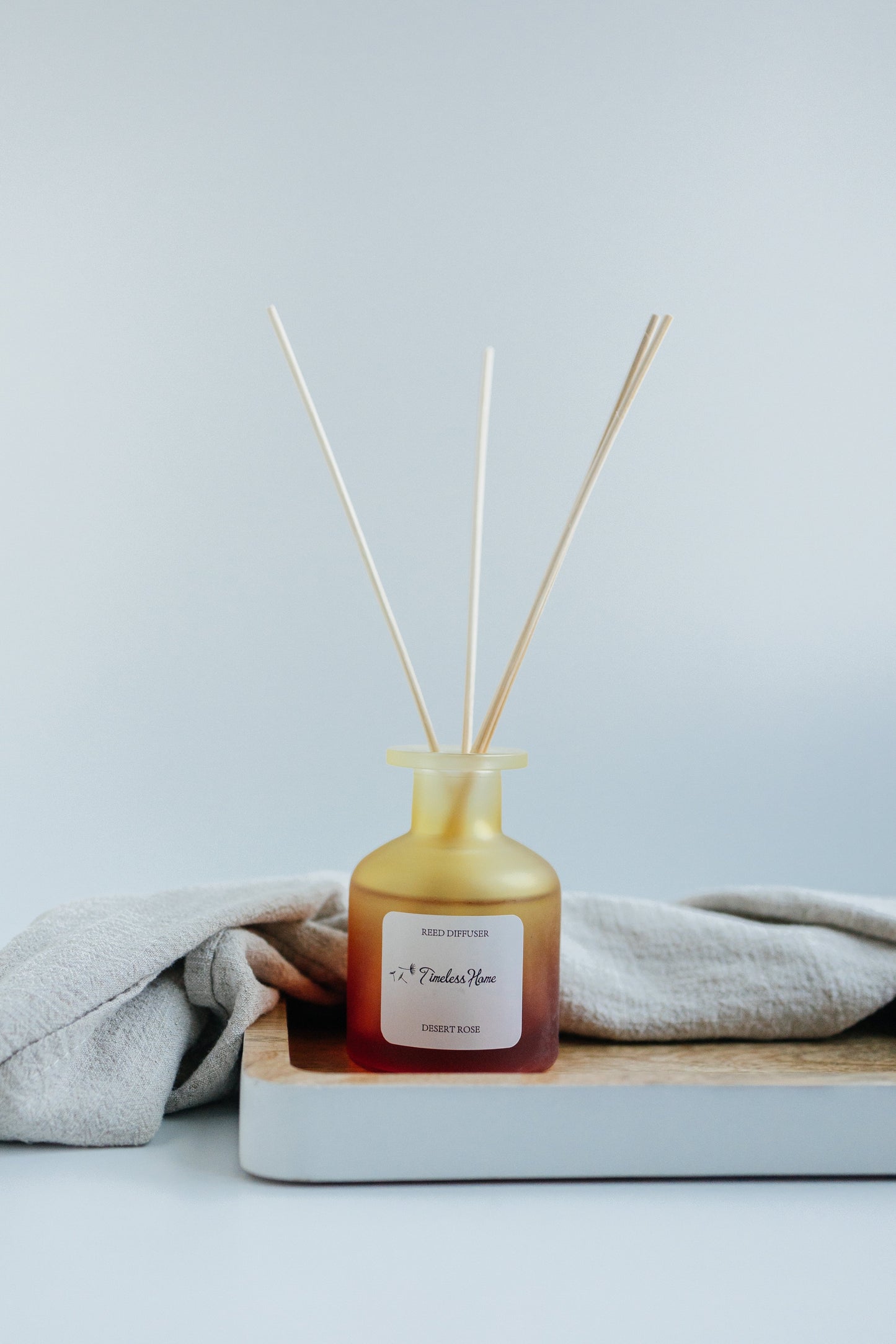 Desert Rose reed diffuser styled on a dark dressing table