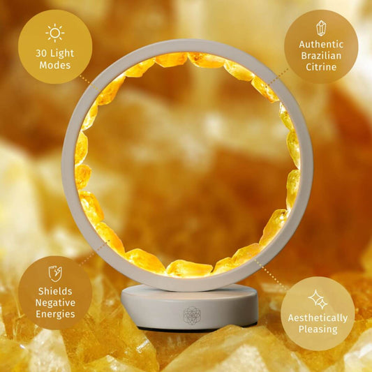 Infinite Abundance citrine halo lamp lined with raw citrine clusters, glowing on a desk