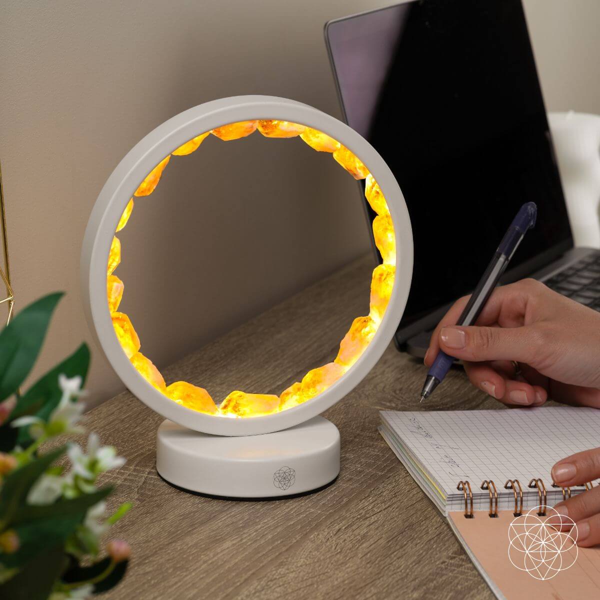 Infinite Abundance citrine halo lamp lined with raw citrine clusters, glowing on a desk (view 2)