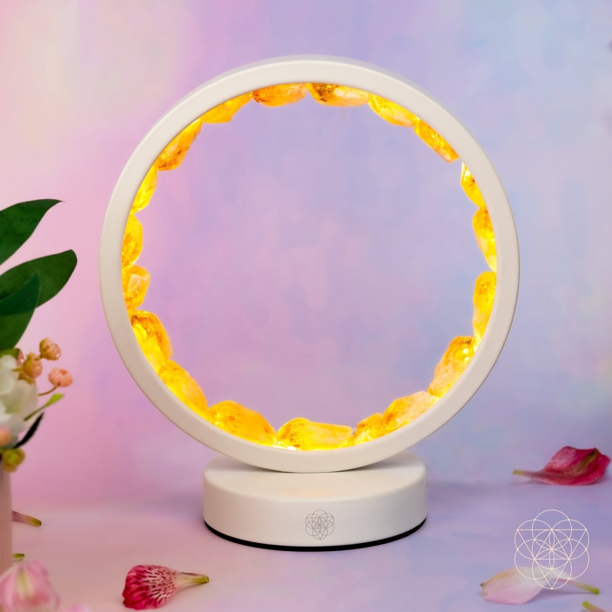 Infinite Abundance citrine halo lamp lined with raw citrine clusters, glowing on a desk (view 5)