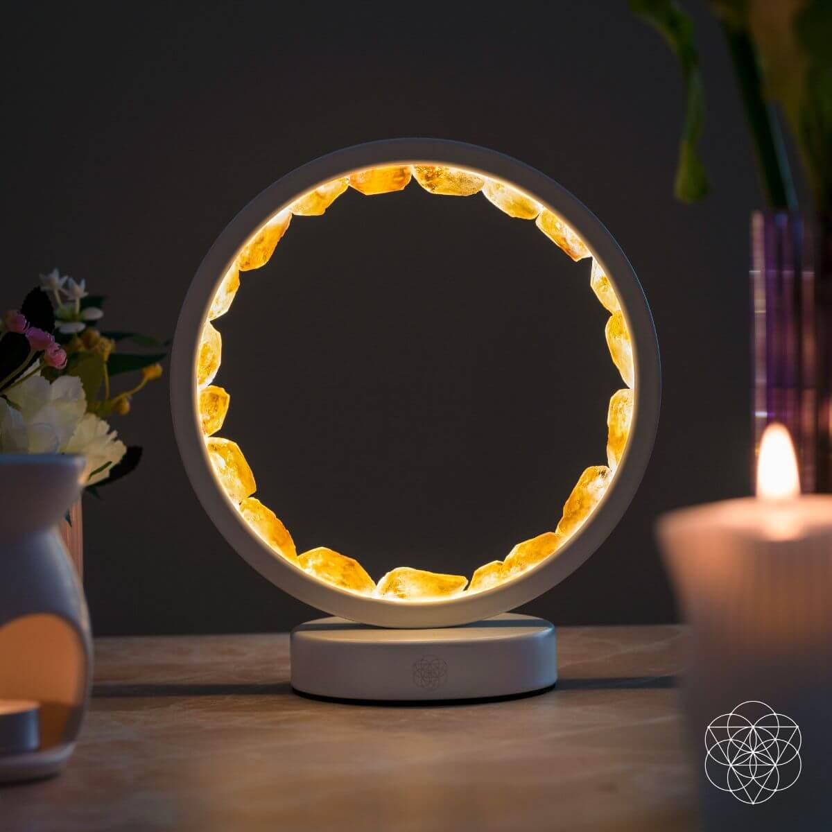Infinite Abundance citrine halo lamp lined with raw citrine clusters, glowing on a desk (view 4)