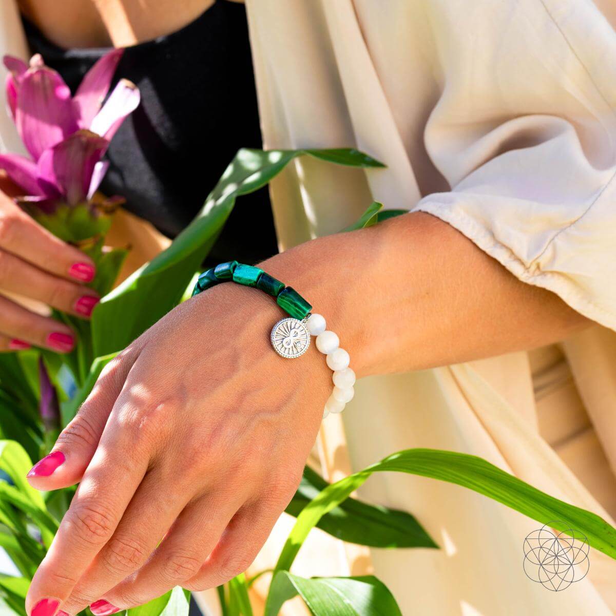 Bracelet with deep green malachite beads on one side and translucent selenite on the other, joined by a platinum-plated infinity charm — detail view 6