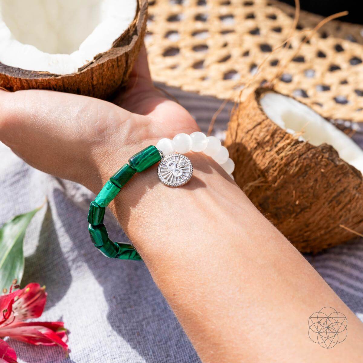 Bracelet with deep green malachite beads on one side and translucent selenite on the other, joined by a platinum-plated infinity charm — detail view 3