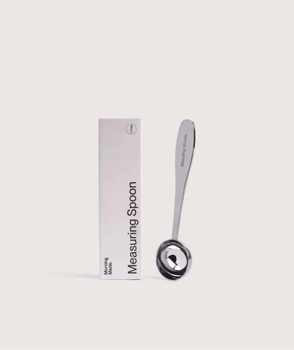 Stainless steel matcha measuring spoon on a dark surface