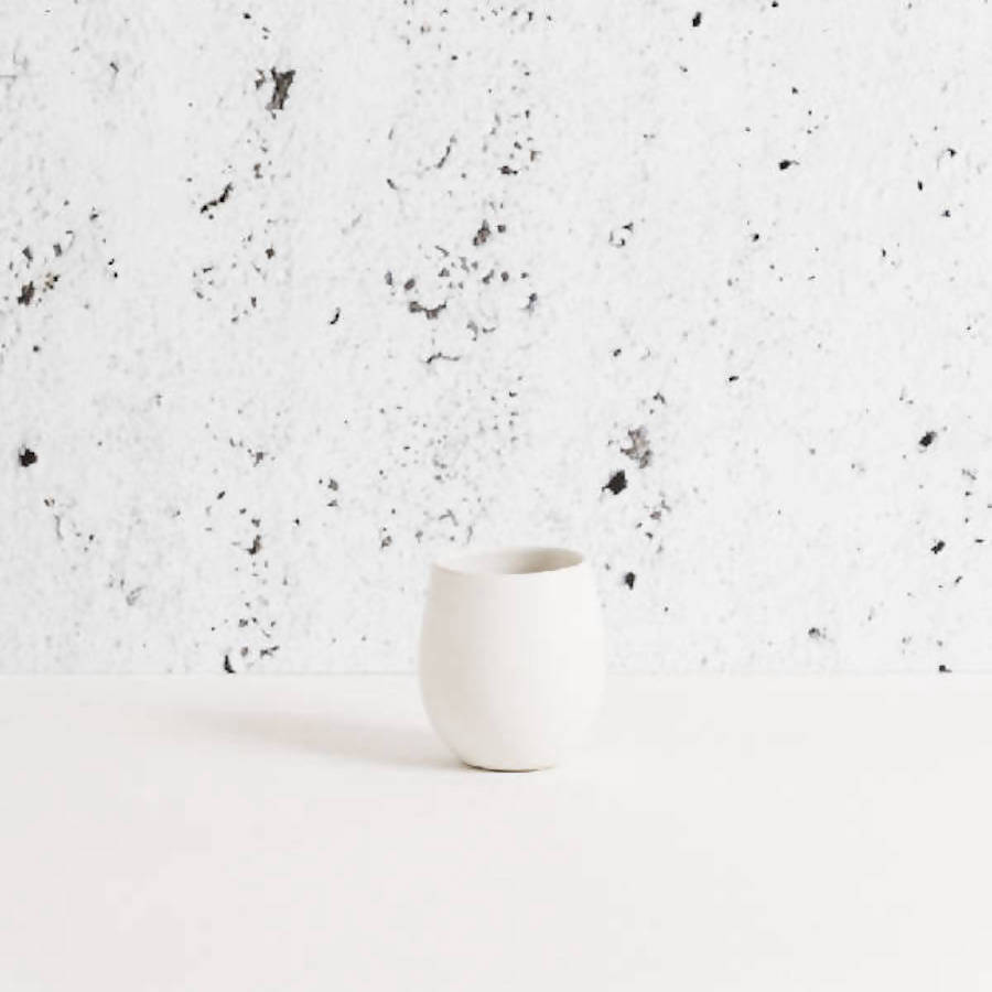 White Epa stoneware cup seen from the side on a pale surface