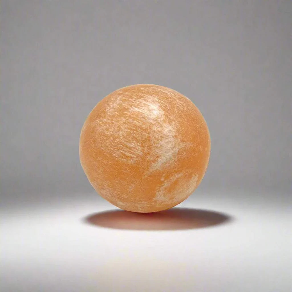Peach selenite pocket sphere with a soft satin finish