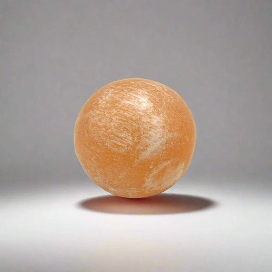 Peach selenite pocket sphere with a soft satin finish