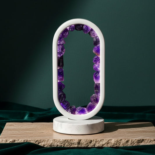 Oval amethyst portal lamp lit from within on a stone plinth against dark green, raw purple points set around the white ring.