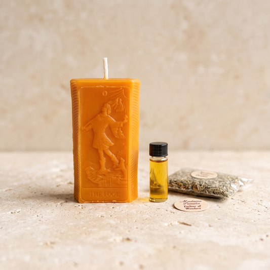 The Fool candle spell kit with an orange beeswax tarot candle and a bottle of spiritual oil