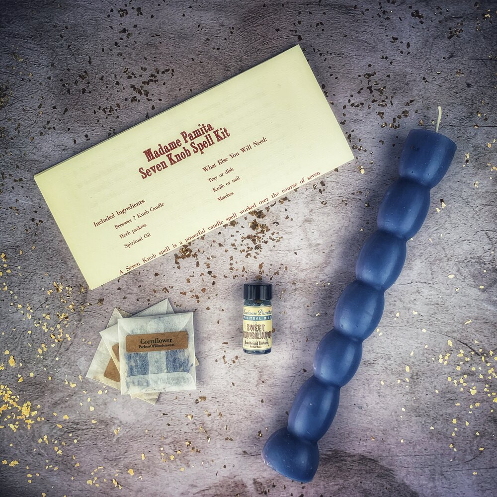 Herb packets and consecrated spiritual oil included with the Seven Knob Candle Spell Kit.